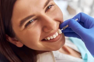 Dentista en Hospitalet valorando el color y ajuste de una carilla o funda dental a una paciente